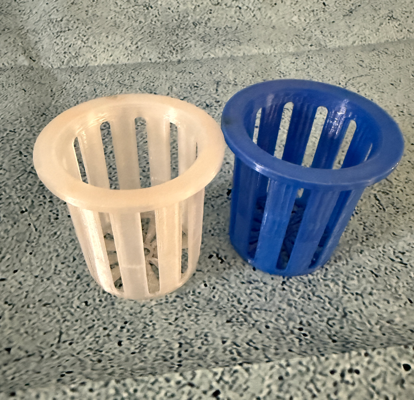 Reusable blue and white hydroponic pods for seed germination and root support