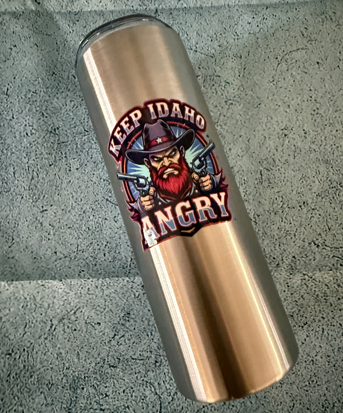 Stainless Steel tumbler with a graphic design on a concrete surface
